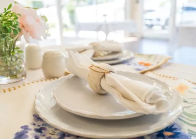 A beautiful table setting with flowers and a sunny view outside