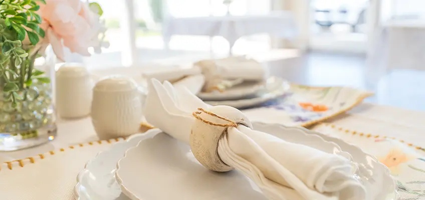 A beautiful table setting with flowers and a sunny view outside