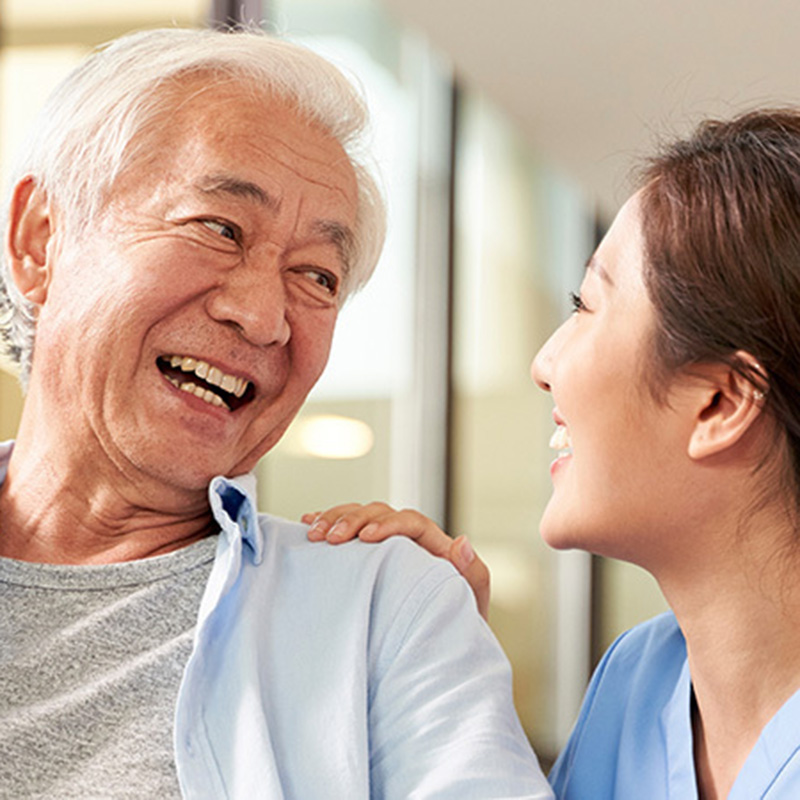 An elderly man smiling at a nurse