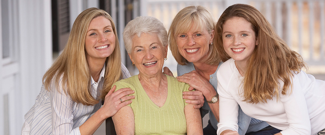 An elderly woman smiling with her family members