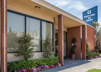 The front entrance of the Meadows on Sunset facility with a big blue sign of the facility name next to the building