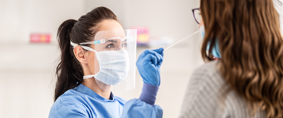 Nurse conducting a COVID exam on a woman